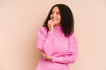 Young african american curly woman isolated relaxed thinking about something looking at a copy space.