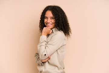 Young african american curly woman isolated smiling happy and confident, touching chin with hand.