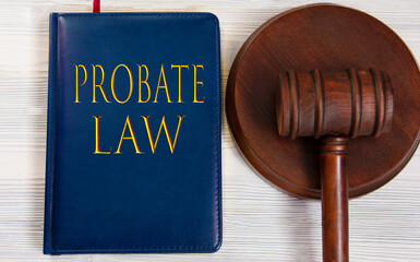 PROBATE LAW - words on a dark blue book on a light wooden background with a judge's hammer on the stand