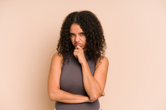 Young african american curly woman isolated thinking and looking up, being reflective, contemplating, having a fantasy.