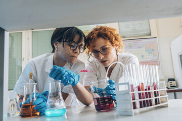 Two female chemistry scientists and students doing experiments in the lab.	
