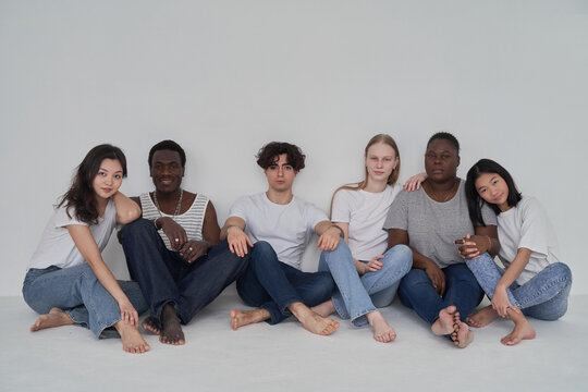 Diverse friends sitting near wall