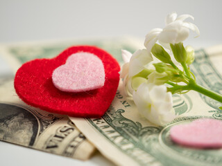 Red hearts and dollars. The concept of love for money. close-up.