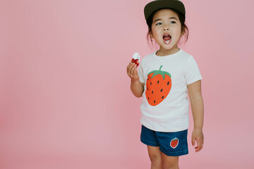 Pink Background with Girl Eating a Strawberry