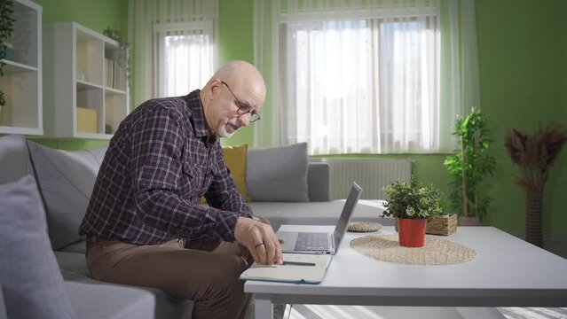 Frustrated old man working on laptop at home.
Frustrated and senile old man working on laptop and surprised by what he sees on screen.
