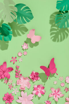 Pink paper flowers on green background. Cut from paper.