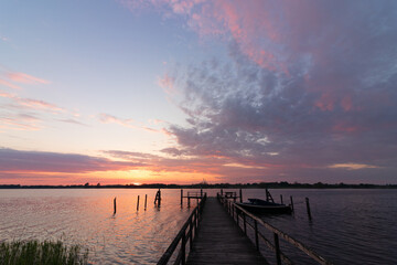 Obraz premium Wooden jetty at the Schlei fjord in Sieseby with epic sunset sky.
