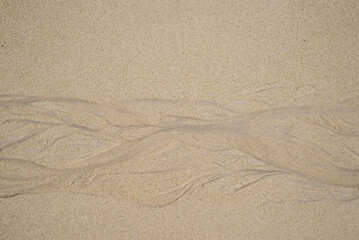 Natural texture of sand. Abstract beautiful drawings on the sand. Paintings in the sand
