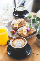 Table full of food and coffee prepared by a barista in a black cup on a restaurant table. Breakfast, lunch and brunch. Beginning of the day.