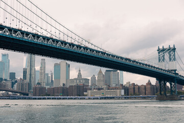 modern skyscrapers and Manhattan bridge above Hudson river in New York City.