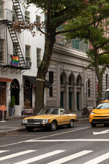Retro car on urban street near buildings in New York City.