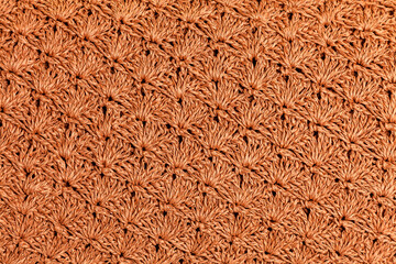 Repeating leaf texture crocheted from a natural cord of dark straw color.