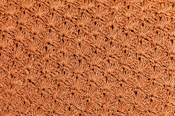 Repeating leaf texture crocheted from a natural cord of dark straw color.