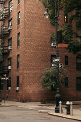 Pointers on lantern near road and brick building on street in New York City.