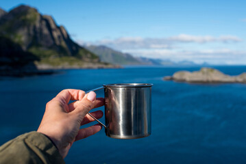 Close-up of woman hand holding mug. The adventure begins travel, hiking and camping concept
