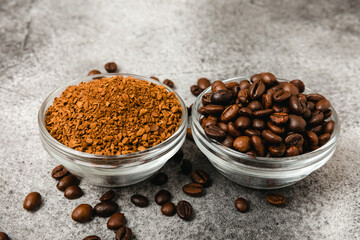 Coffee granules and coffee beans on a black textured background. Instant coffee drink. Energy hot drink. Place for text. Place for copy. Cheerful morning concept.