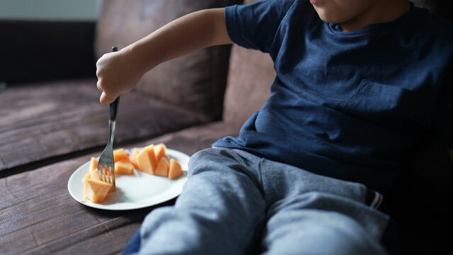 Little Boy Holding Fork Grabbing Orange Melon On Plate Eating Healthy Food