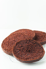 Fresh sliced sponge chocolate cake biscuit. Cake assembly process background. Cake recipe.