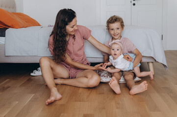 Mother and children on floor near bed