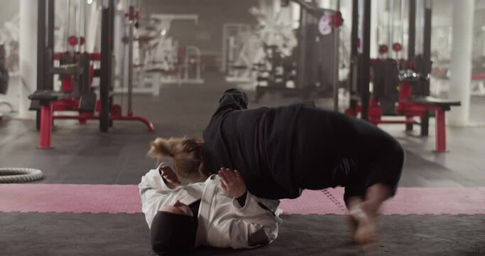 Female fighters doing BJJ drill in gym
