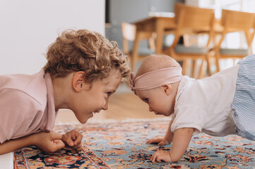 Cute siblings on floor at home