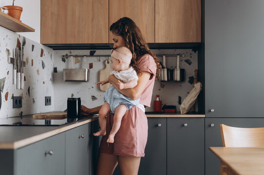 Mother with baby in kitchen at home