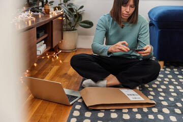 Woman scans parcel code at home