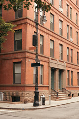 Lantern with pointers near building on urban street in New York City.