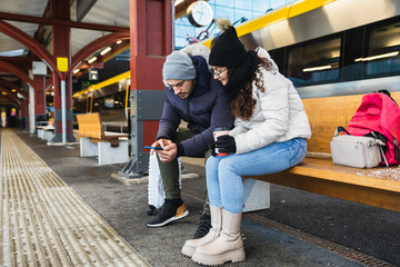 Couple sitting on bench in a train station