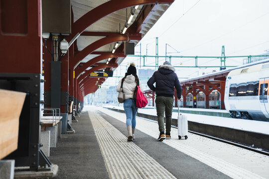 Couple walking with suitcase in a train station