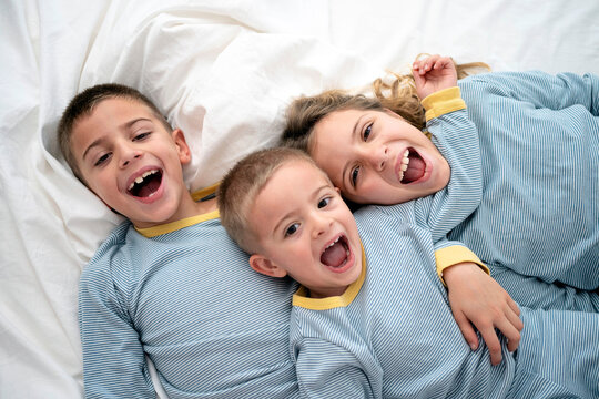 Portrait of three cheerful children in pajamas.