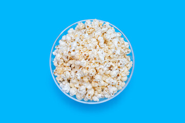 Popcorn in a large glass bowl on a deep background with a top view. Crispy classic popcorn snack for watching movies and series. Delicious light snack for watching TV and evening leisure