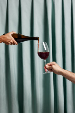 Cop person serving and pouring red wine in glass
