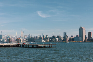 Fototapeta na wymiar picturesque view of New York bay with pier and skyscrapers of Manhattan.