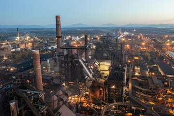 Smelter with blast furnaces from above during evening. Heavy industry plant with lights.