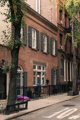 Fototapeta na wymiar Brick building with shutters on windows on street in New York City.