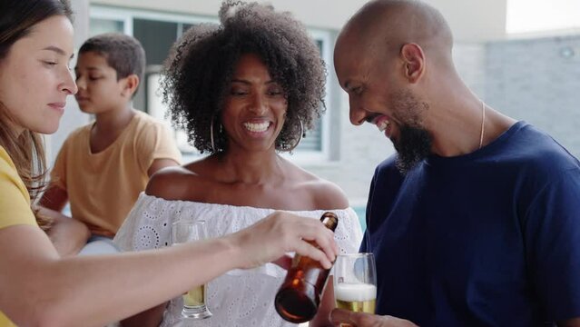Happy friends gathering and eating in a traditional brazilian barbecue. Drinking beer. 