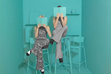 Conceptual funny portrait with fashionable girls reading a book