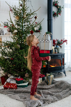 Child with stack of Christmas gifts