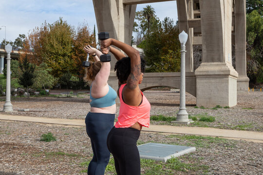 Women working out with weights together outdoors