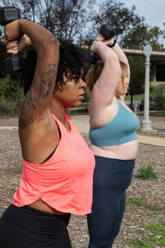 Women working out with weights together outdoors