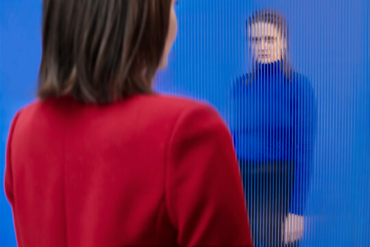 Two persons standing in front of each other against blue background