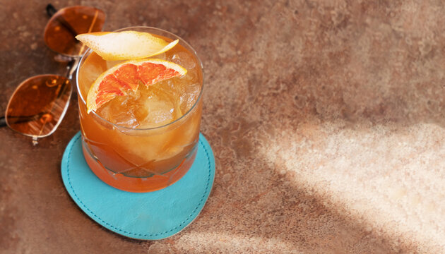 Old fashioned cocktail with orange on metal table. Copyspace