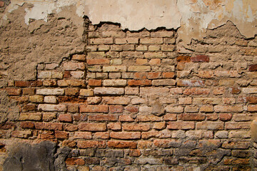 Old brick wall with crumbling plaster, grunge background