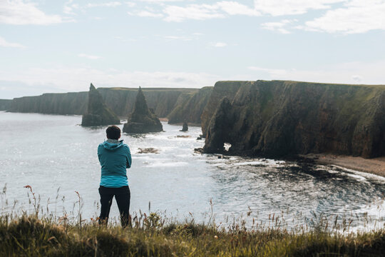 Man relaxing at Sea Stacks At Duncansby Head. Highlands, Scotland