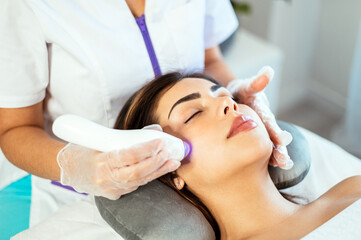 Calm lady getting ultraphonophoresis and pimple reduction in clinic