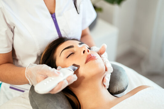 Cosmetologist giving facial cleaning to client
