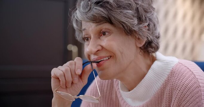 Portrait of elderly lady watching TV and smiling, 4k