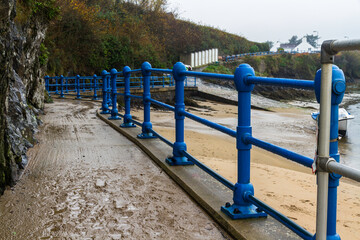 Blue hand rails leading from a beach.