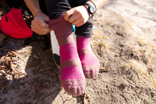 A pair of legs putting on socks to go skate 